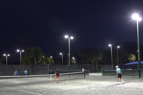 People playing tennis under the light at the Boca Raton Swim & Racquet Center