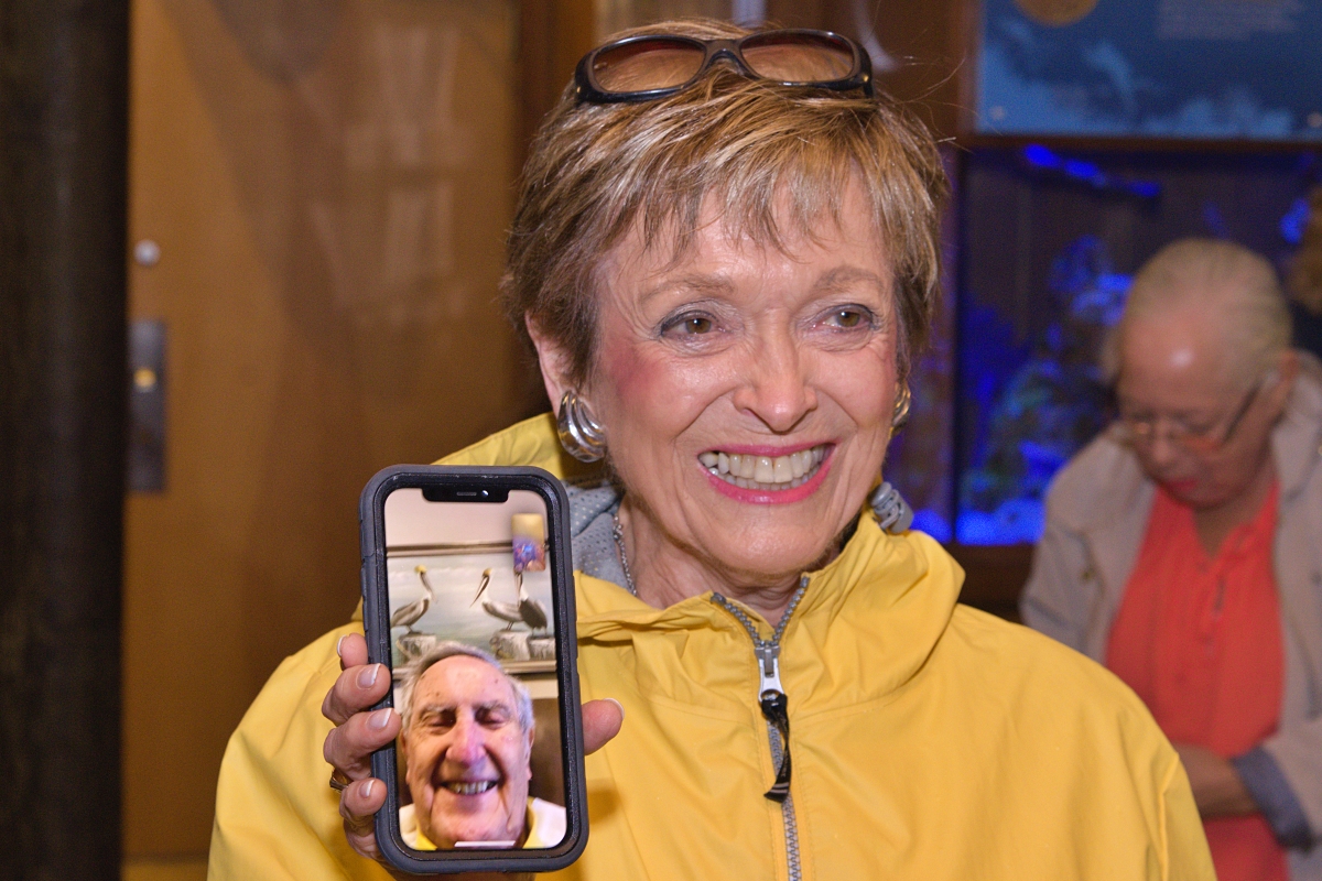 Connie Talcott Smith holds the phone bringing Gordon Gilbert to the Jacob's Outlook opening via Facetime.
