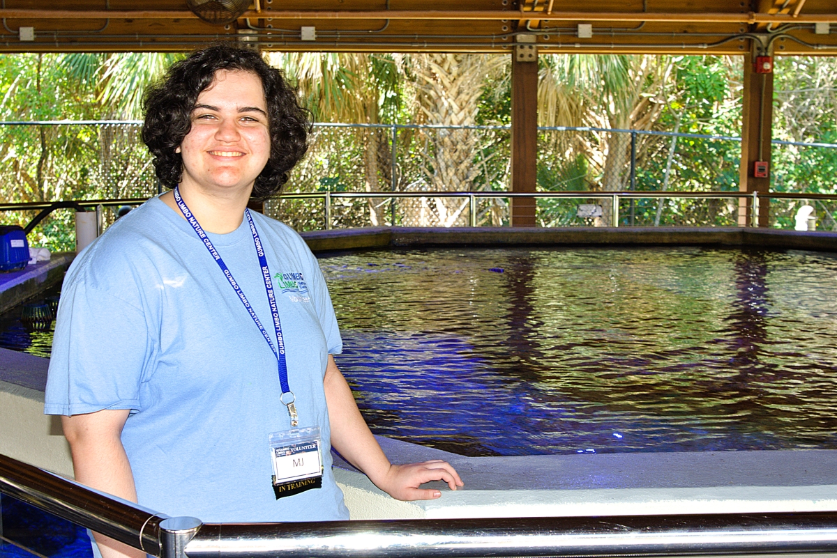 Mikaela Hill next to a tank at the Gumbo Limbo Center