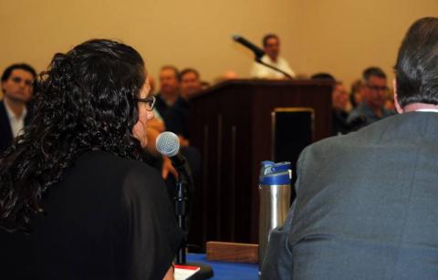 Commissioner Erin Wright listens to a speaker.